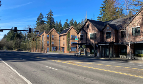 A street view of a row of houses with a traffic light in the background.