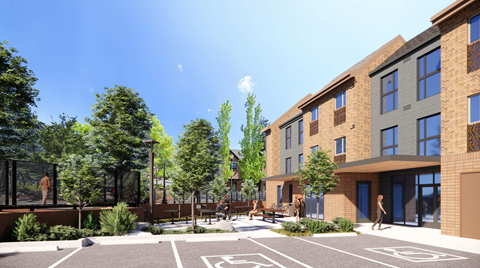 A modern building with a parking lot in front.