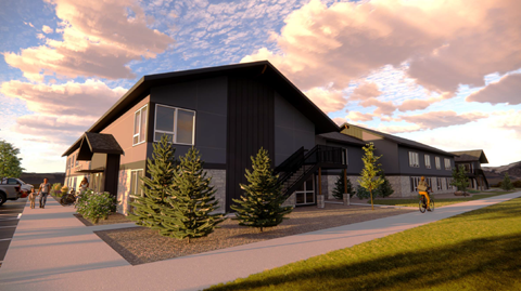 A modern building with a grey exterior and a few trees in front.