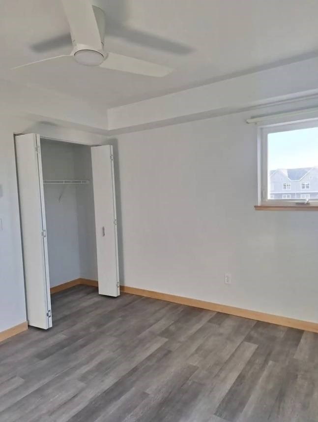 A room with a ceiling fan and a doorway leading to another room.