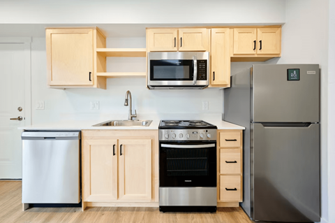 A kitchen with a stove, oven, refrigerator, and microwave.