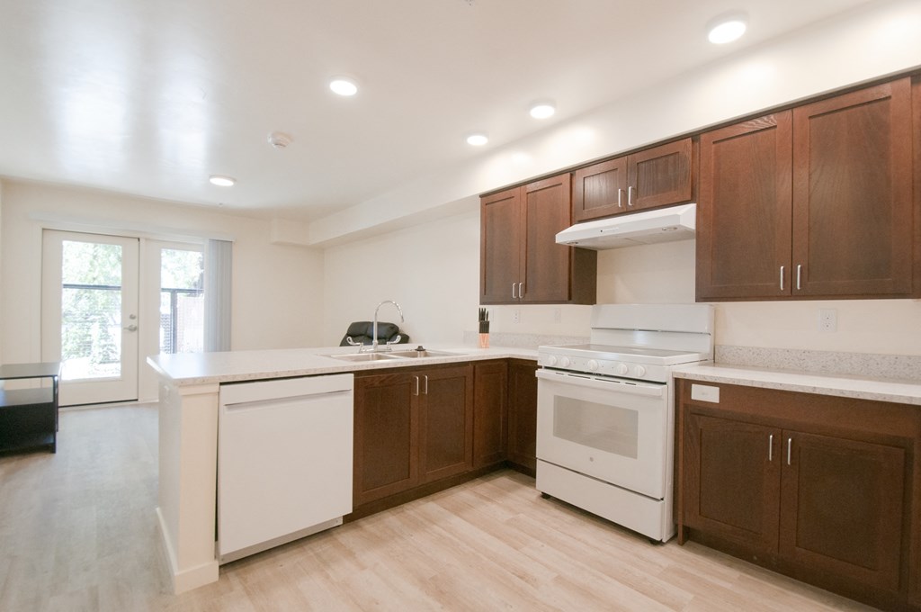 a large kitchen with white appliances and wooden cabinets