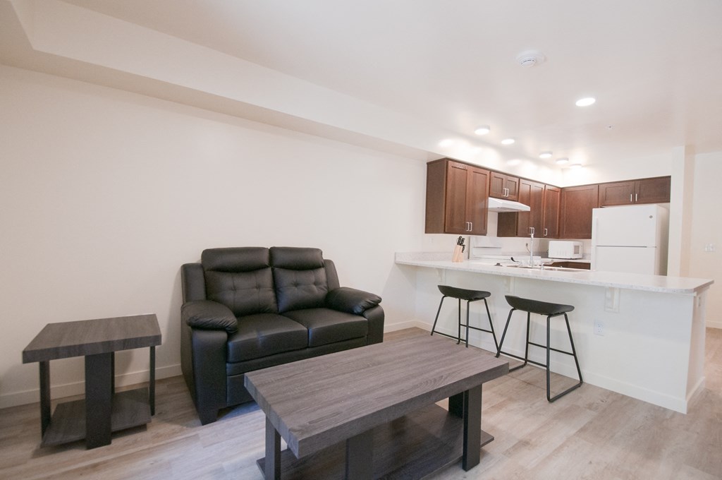 a living room with a couch and a kitchen with a bar