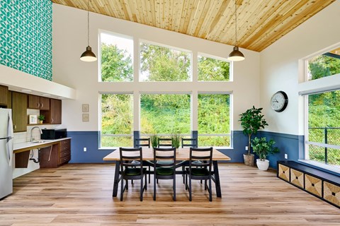 a dining room with a table and chairs and a large window