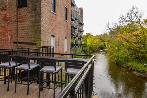 A patio with chairs overlooking a river.