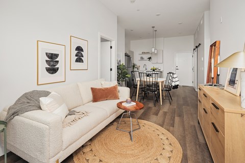 A living room with a white couch and a rug.