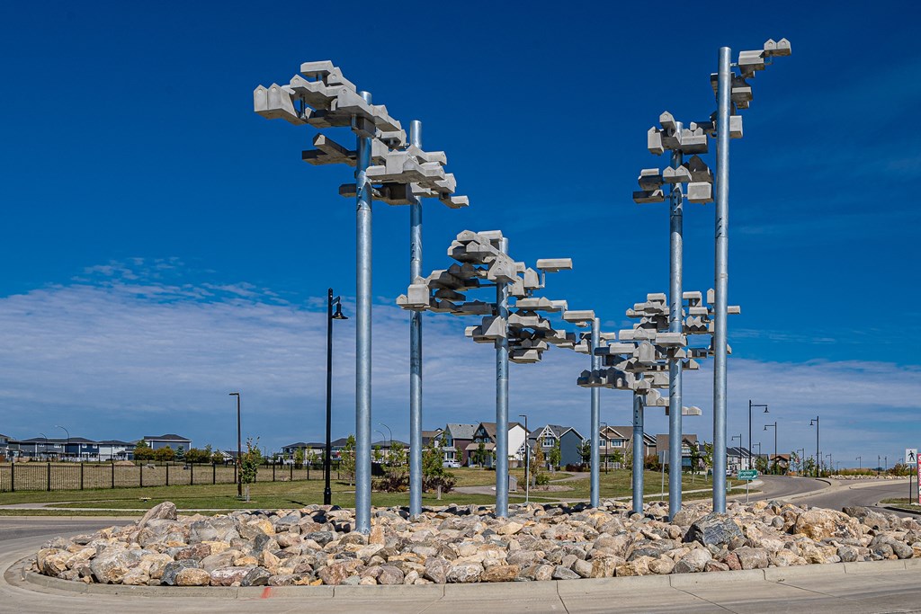 a group of metal poles with lights on them next to a road
