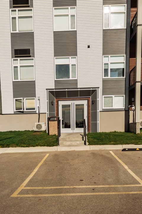 A building with a grey facade and a brown door.