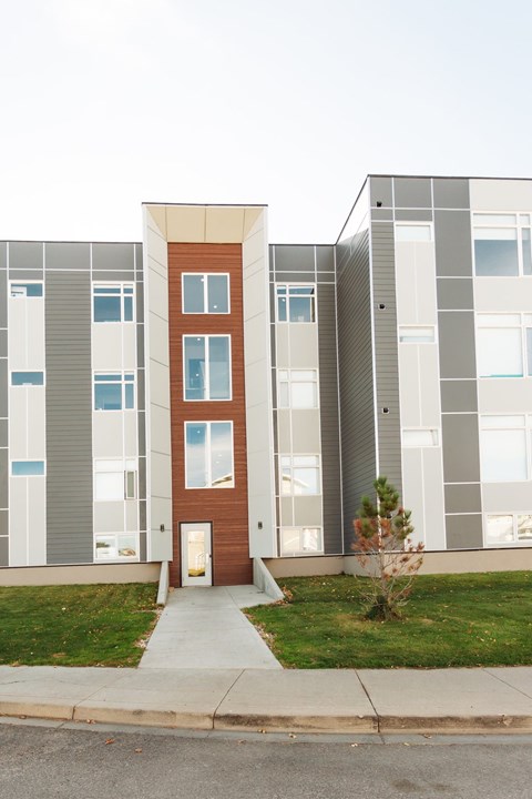 A modern building with a brown door and windows.