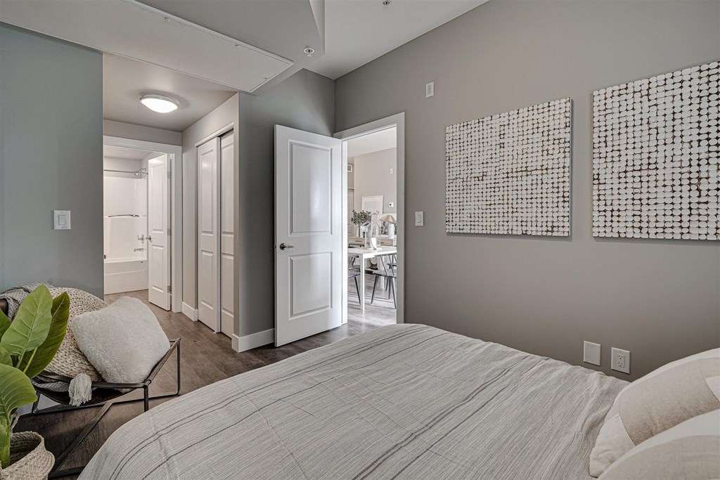 a bedroom with a bed and a door to a dining room