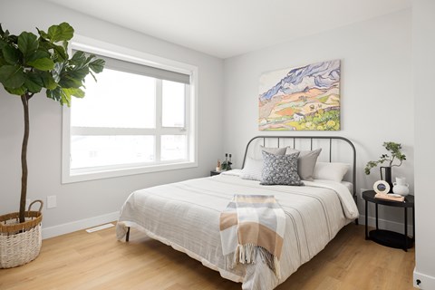 A bedroom with a large bed and a painting on the wall.