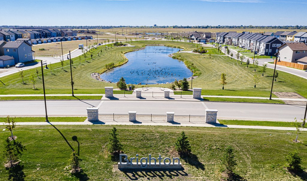 a park with a pond and houses around it
