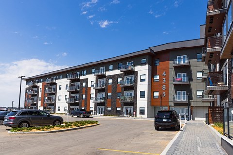 a large apartment building with cars parked in front of it