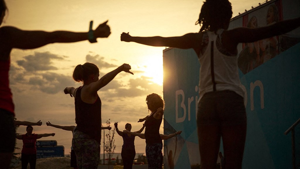 a group of people doing yoga at the beach at sunset