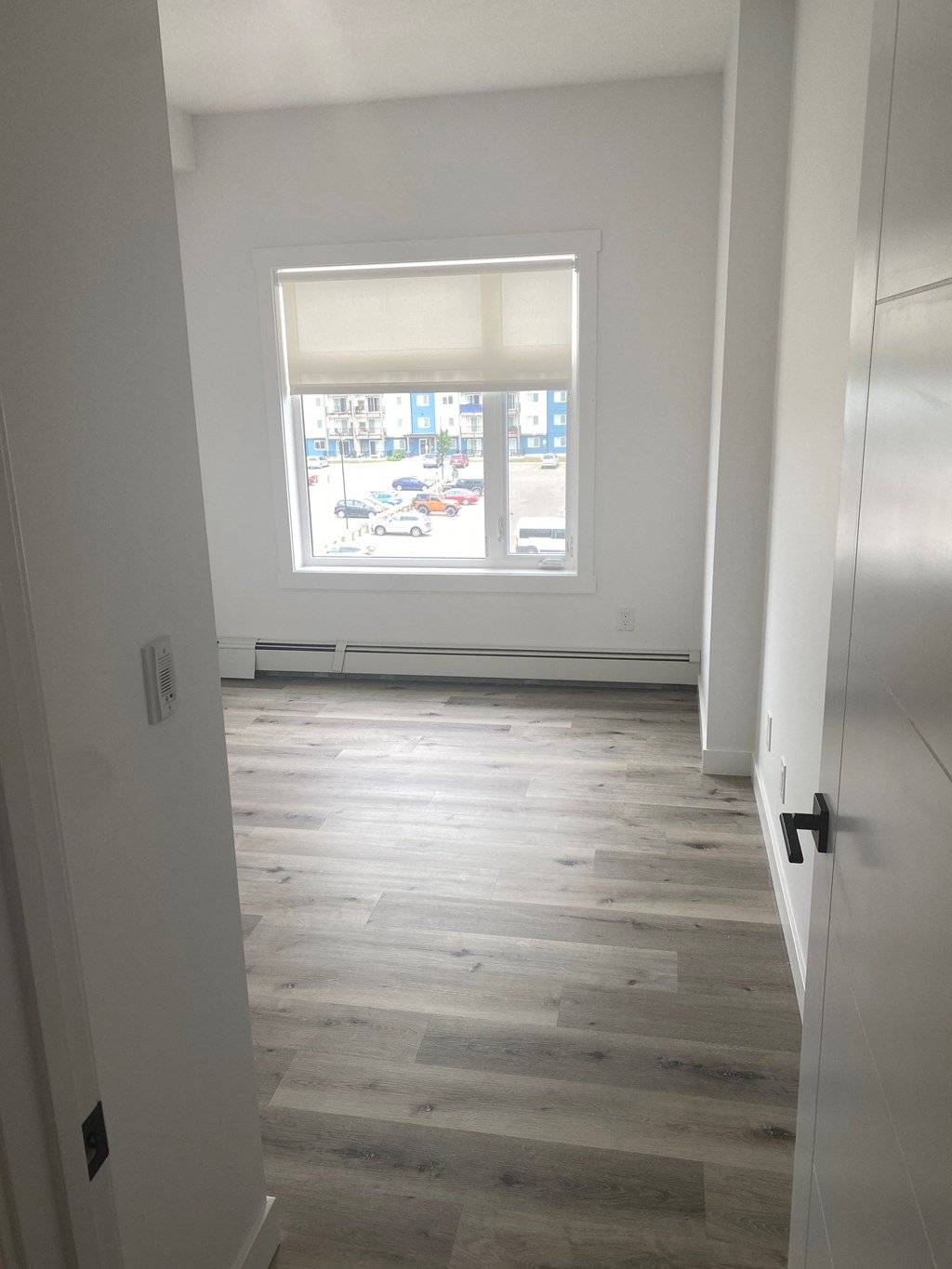an empty room with wood floors and a window