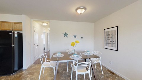 a dining room with a table and chairs and a refrigerator