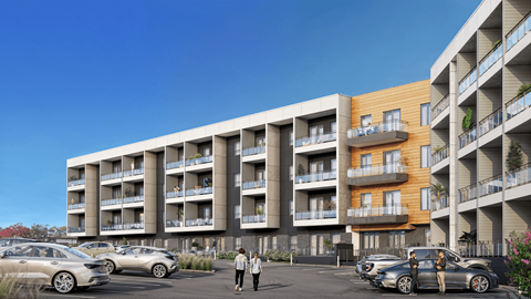 A modern apartment complex with cars parked in front.