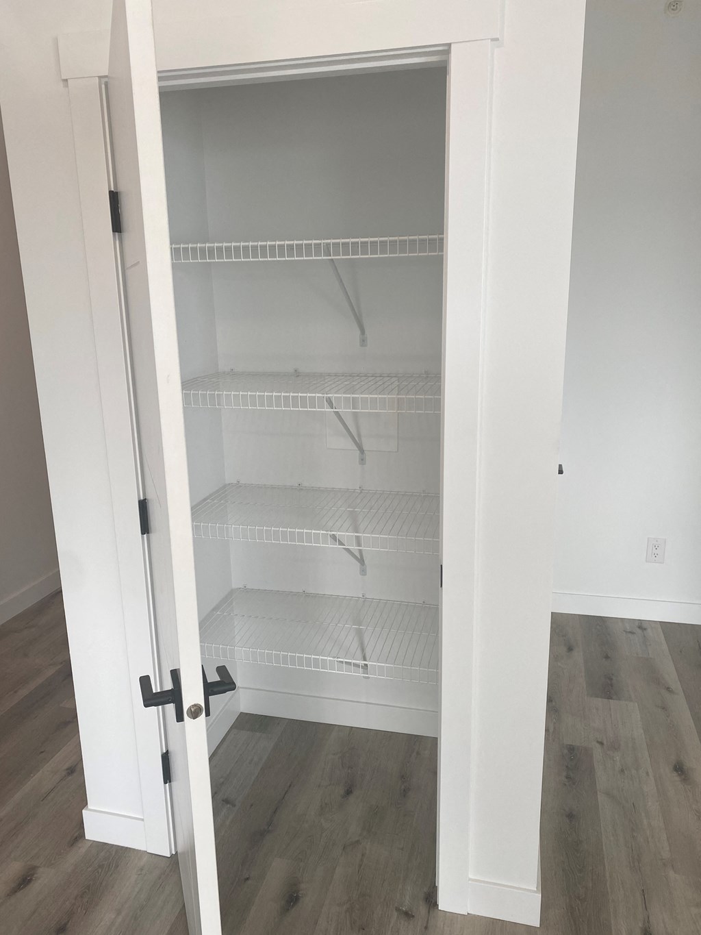 a closet with empty shelves and a door open