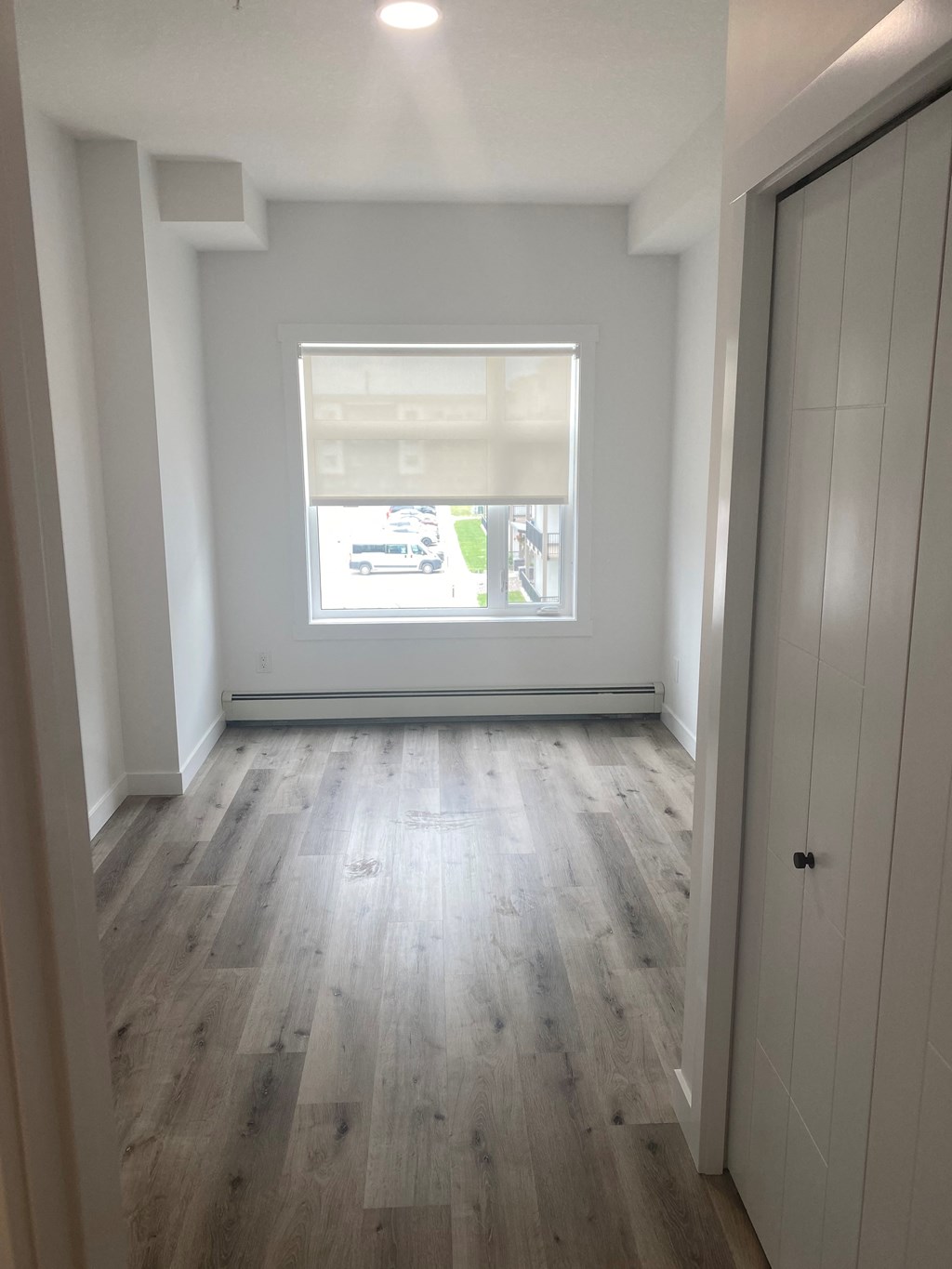 an empty room with wood floors and a window