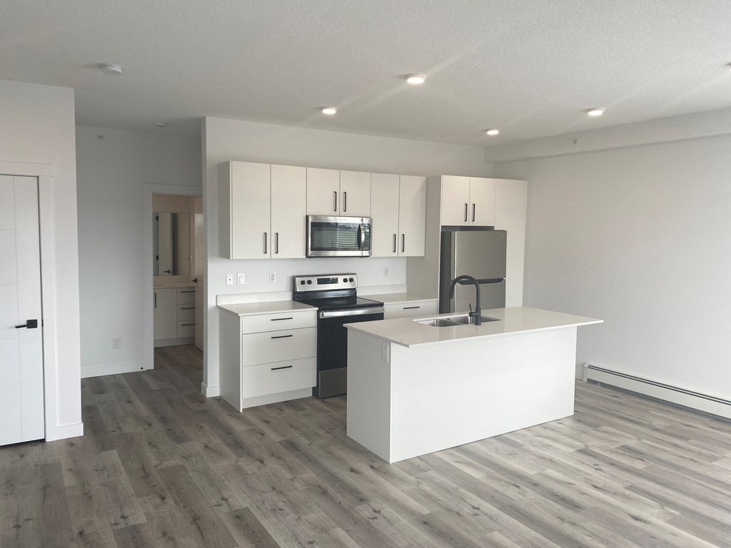 a kitchen with white cabinets and a stove and a refrigerator