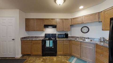 a kitchen with black appliances and wooden cabinets