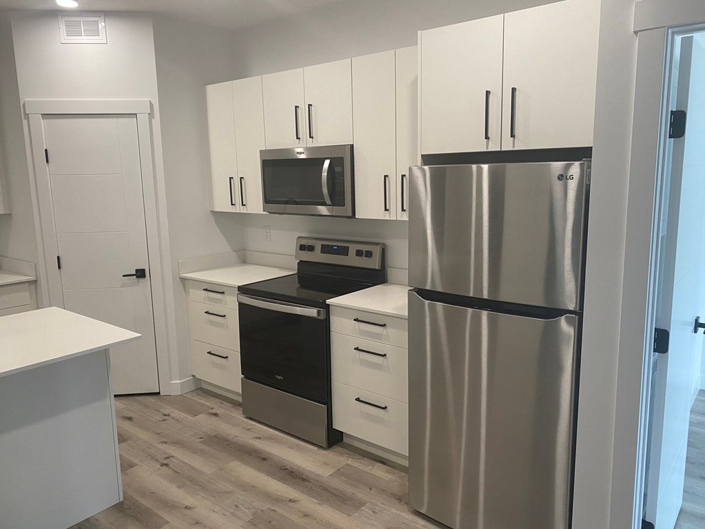 a small kitchen with stainless steel appliances and white cabinets