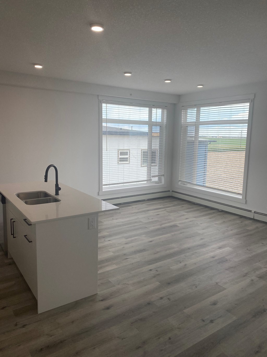 an empty living room with a sink and a window