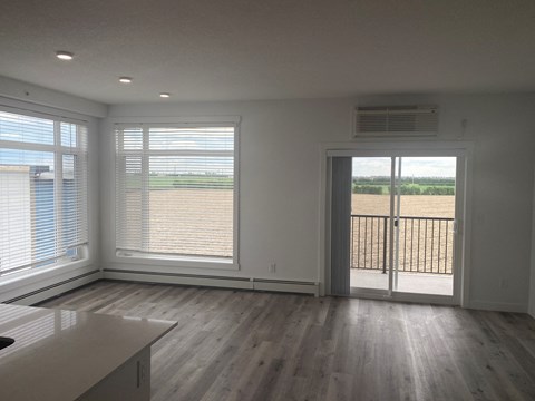 a living room with wood floors and a door to a balcony