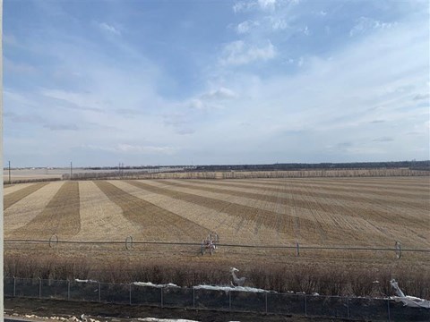 an empty field with a fence in front of it