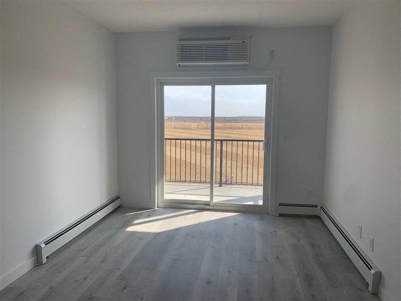 an empty room with a balcony and a view of a field