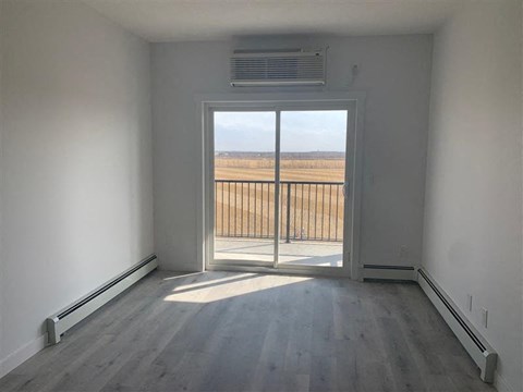 an empty room with a balcony and a view of a field