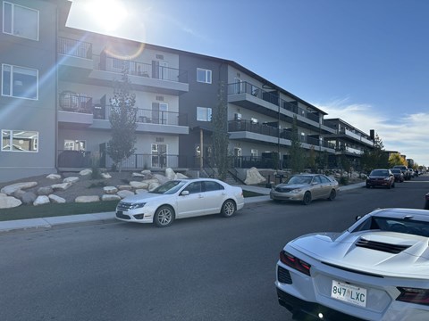 A white car with the license plate 8U7 LXC is parked on a street.