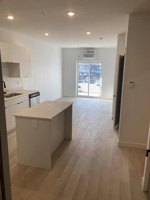 A kitchen with white cabinets and a white island.