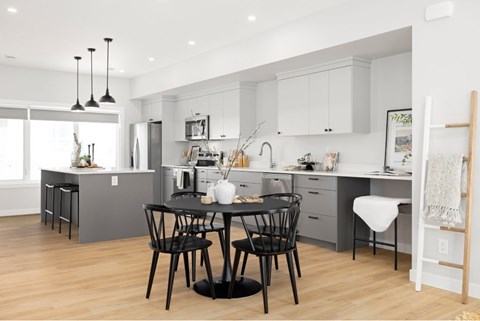 A modern kitchen with a dining table set for two.
