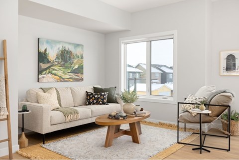 A living room with a couch, coffee table, and a painting on the wall.