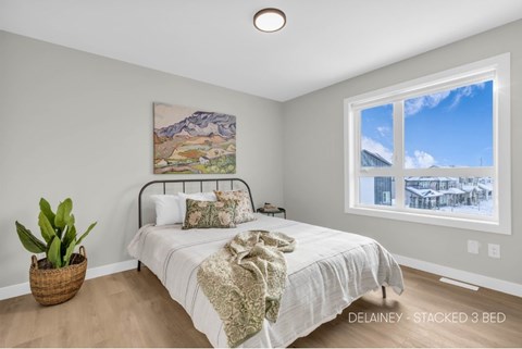 A bedroom with a large bed and a painting on the wall.