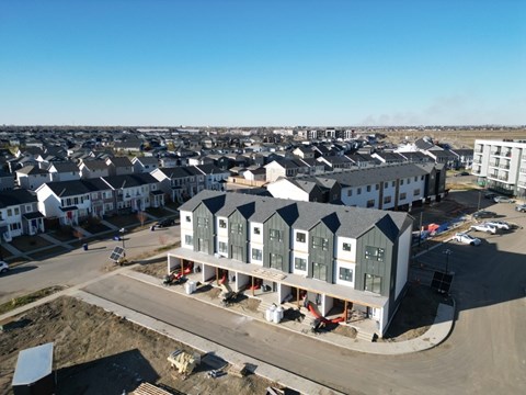 A construction site with a large building under construction in the foreground.