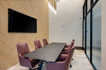 a conference room with a table and chairs and a television at Preston Ridge, North Carolina, 27513