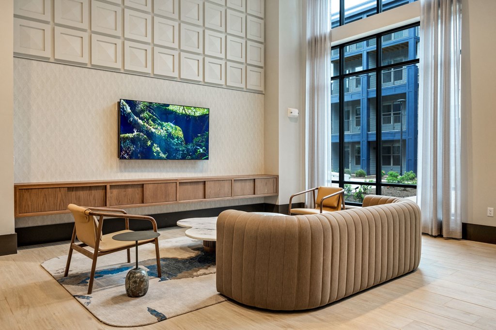 a living room with a couch and chairs and a painting on the wall at Preston Ridge, Cary