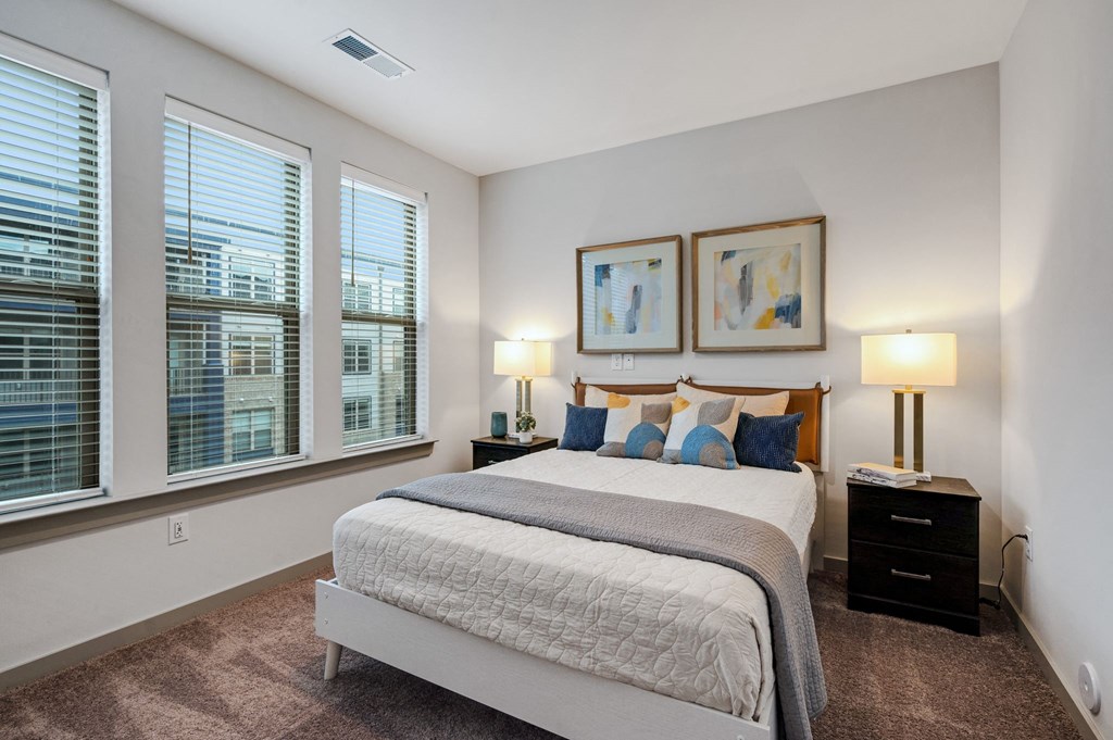 a bedroom with a large bed and three windows at Preston Ridge, Cary, 27513