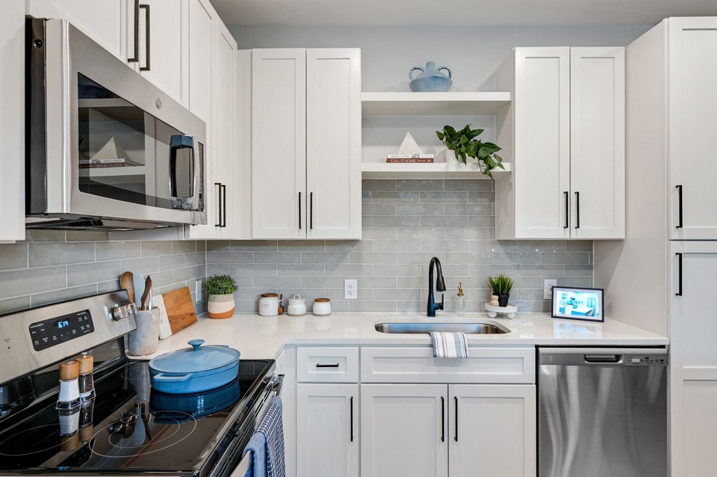 a kitchen with white cabinets and appliances and a sink at Preston Ridge, Cary