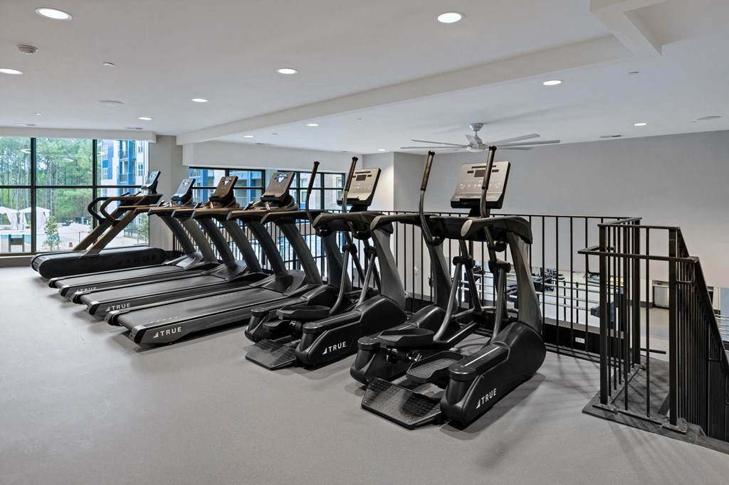 a row of treadmills in a workout room with windows at Preston Ridge, Cary, NC