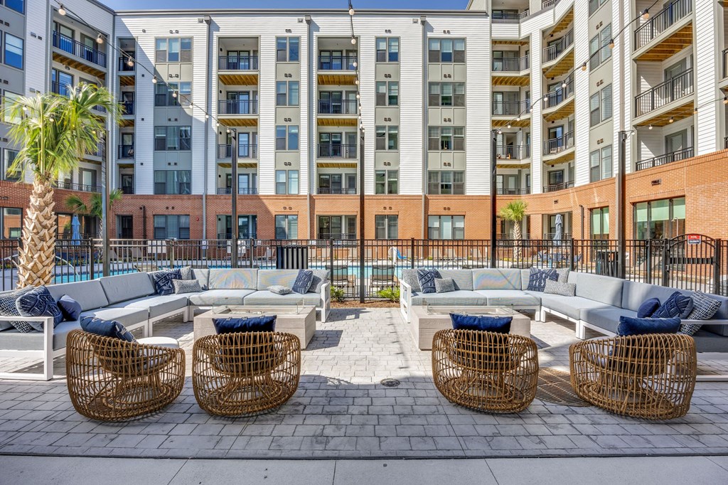 an outdoor lounge area with couches and chairs in front of  Metropolitan at the Riverwalk, Wilmington, NC