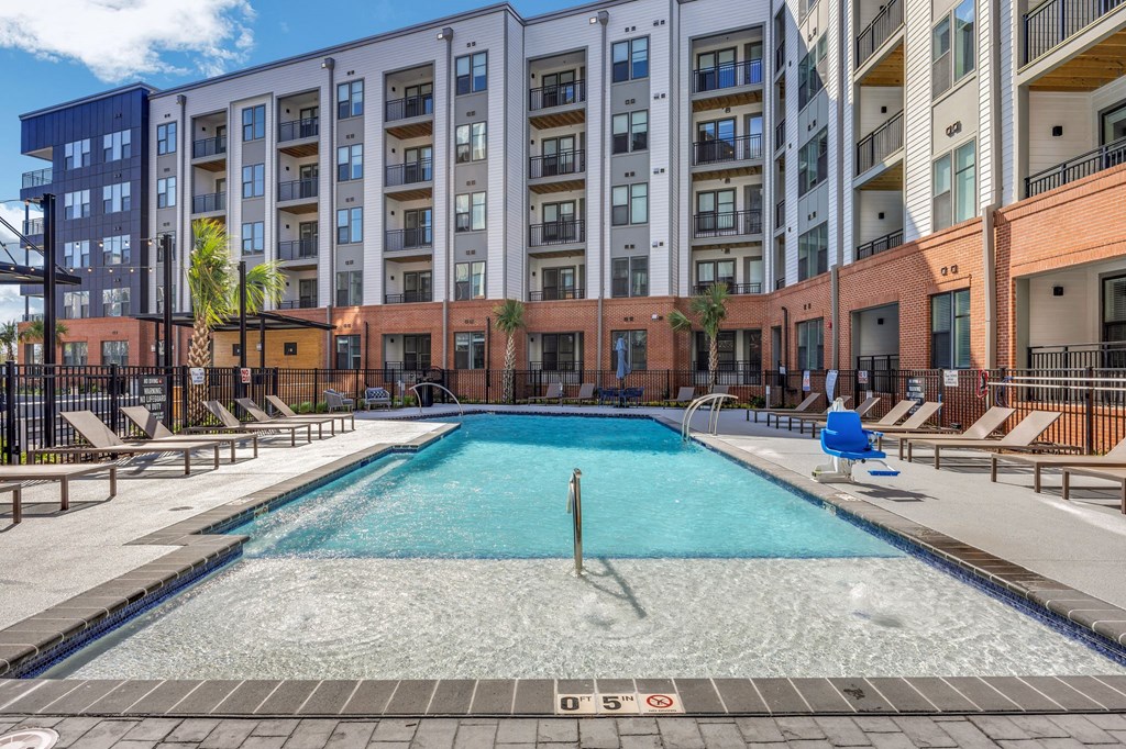 a swimming pool with an apartment building in the background at Metropolitan at the Riverwalk, Wilmington, NC