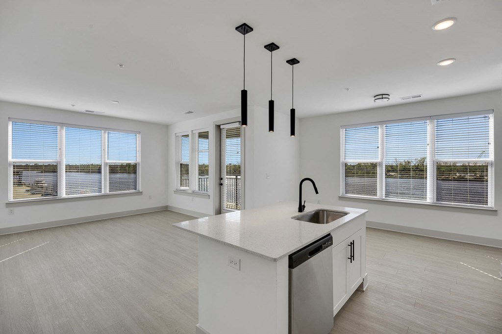 a white kitchen with a large island and windows at Metropolitan at the Riverwalk, Wilmington