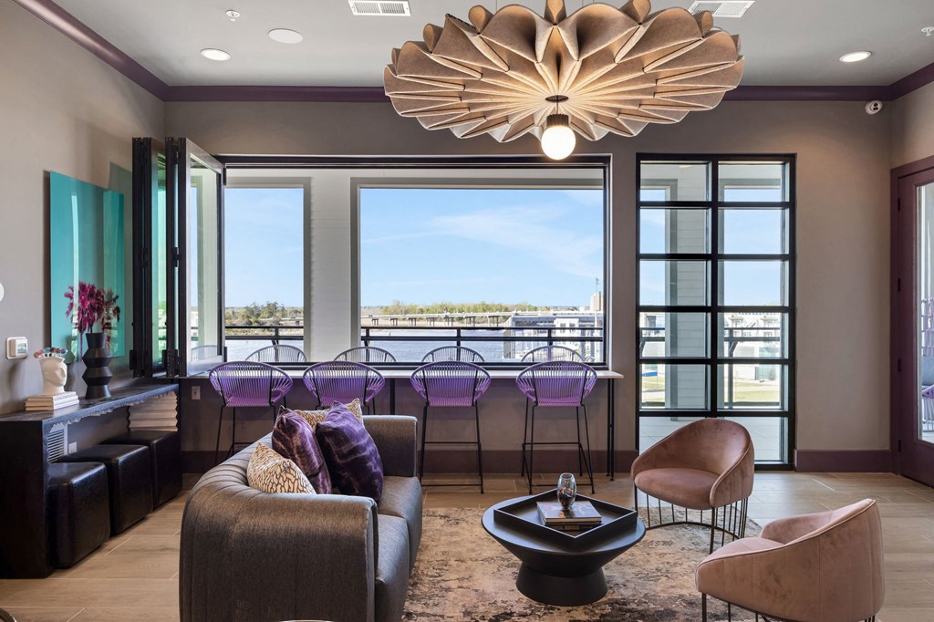 a living room with a bar and a view of the city at Metropolitan at the Riverwalk, Wilmington, NC