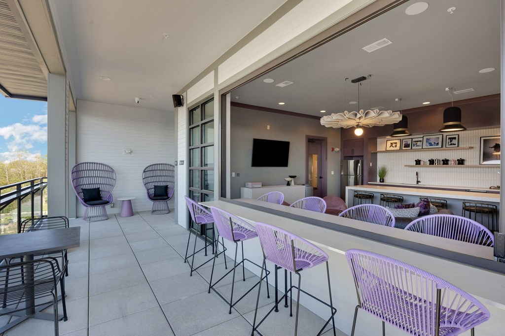 a bar with purple chairs and a counter with chairs at Metropolitan at the Riverwalk, Wilmington, NC