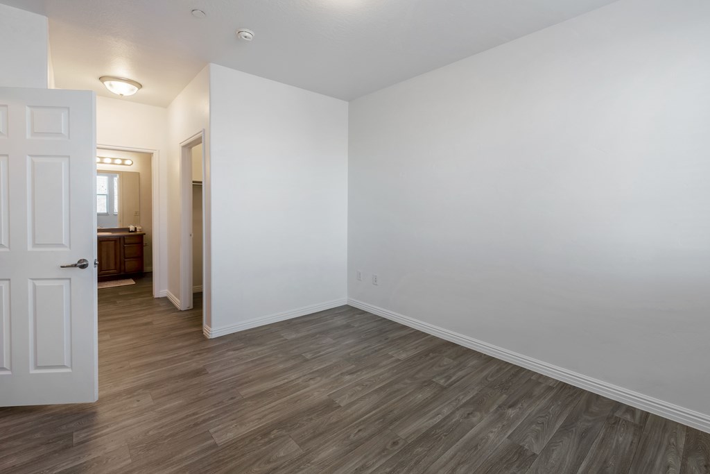 A white door is open to a room with wood flooring.at Florentine Villas, Midvale, UT 84047