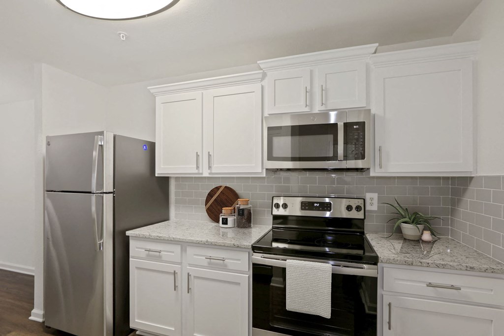 a kitchen with stainless steel appliances and white cabinets at The Fields of Manassas in Lorton, VA