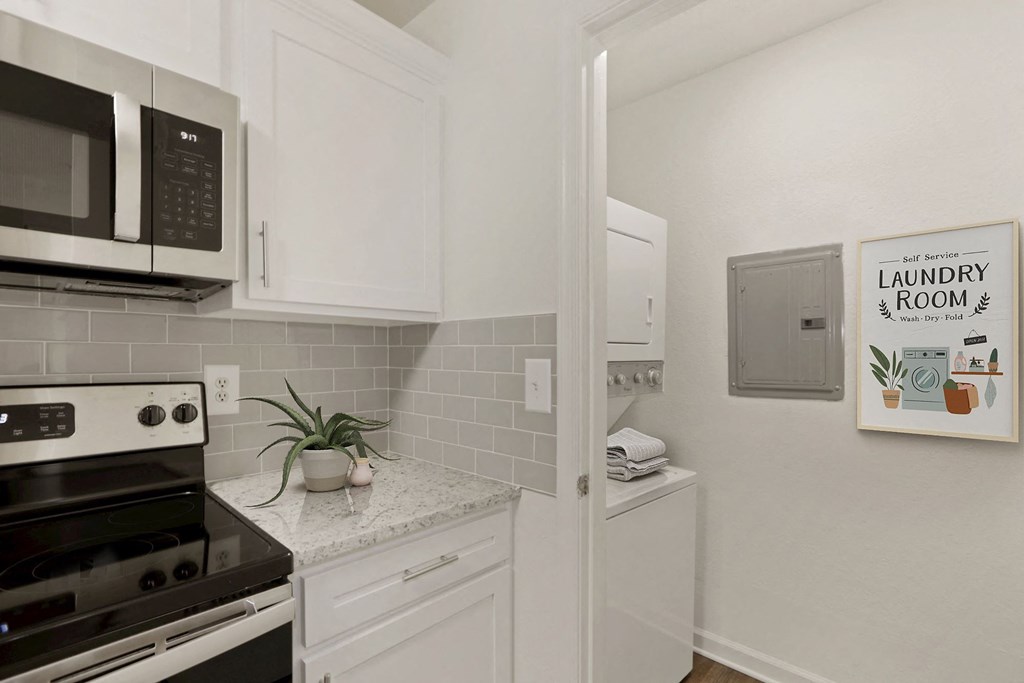 a kitchen with white cabinets and a stove and a microwave